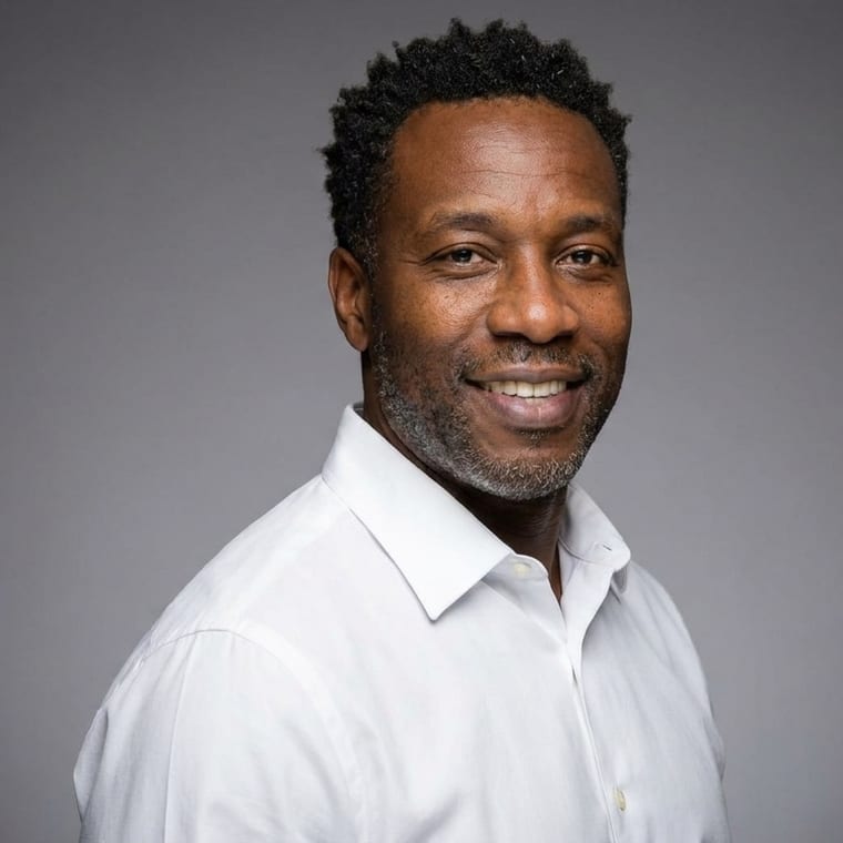 The same agent against a soft grey gradient backdrop, lit with clamshell lighting, body turned three-quarters to the camera.