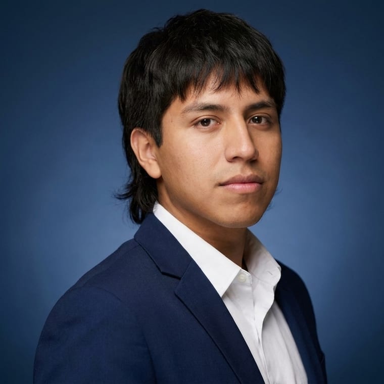Young man in navy blazer against a blue studio background