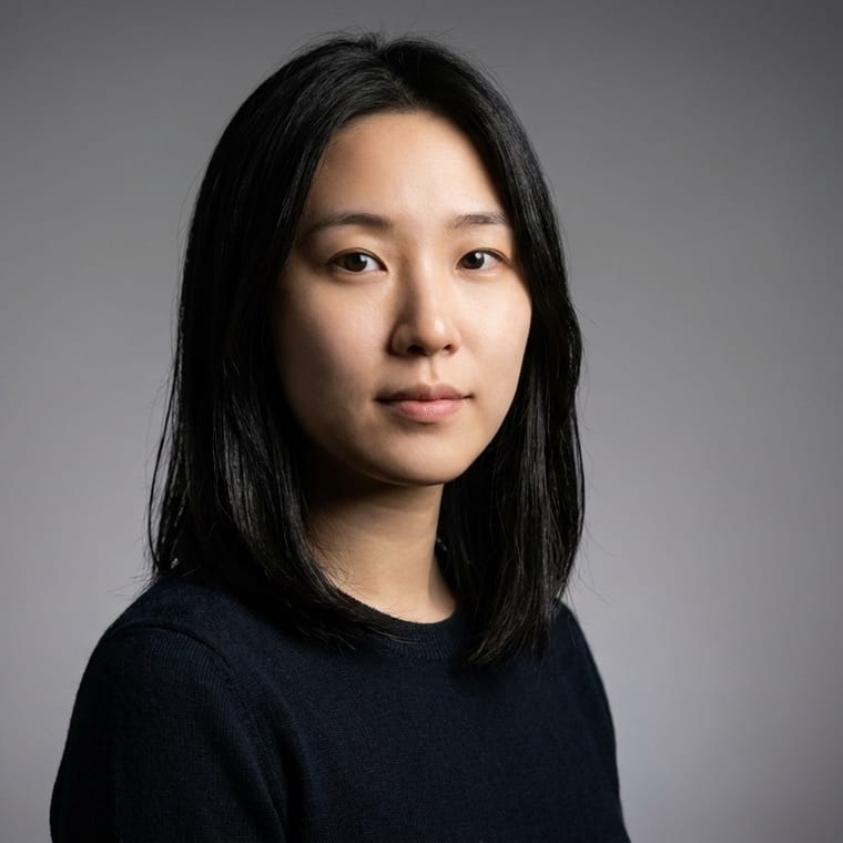 The same subject against a soft grey gradient backdrop, lit with a Rembrandt key light, facing the camera square on, medium crop.